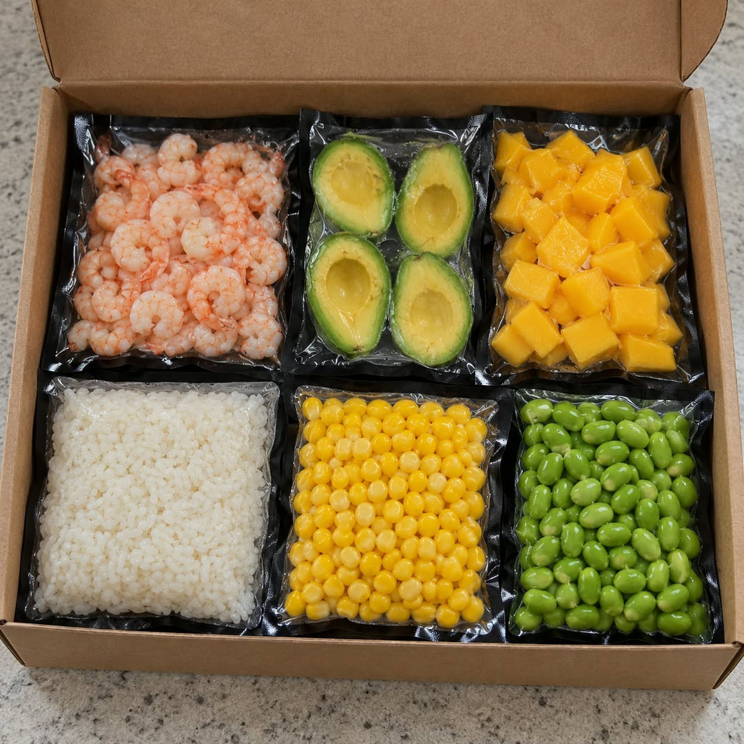 Boîte ouverte contenant des crevettes nordiques, du riz collant, des demi-avocats, des mangues en cubes, du maïs et des edamames, emballés séparément.