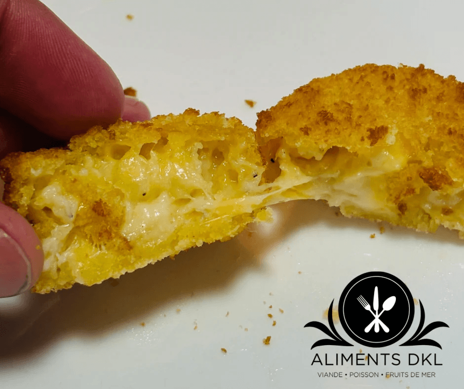 Bouchées dorées de Mac & Cheese deluxe sur une assiette noire, dont une ouverte montrant le macaroni aux quatre fromages.