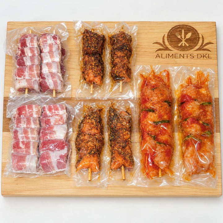 Brochettes de filet mignon et bacon, de saumon à l’érable et de poulet BBQ aux légumes, emballées sous vide sur une planche en bois Aliments DKL.